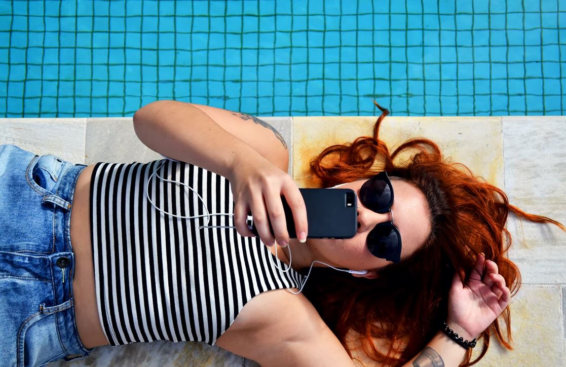 Woman using phone by pool