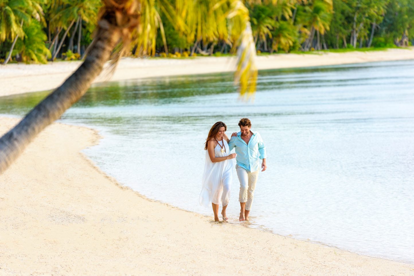 Couple walking down beach in Fiji